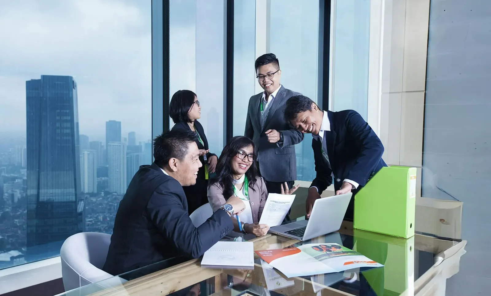 Nhóm điều hành cùng xem tài liệu trong phòng họp nhìn ra thành phố